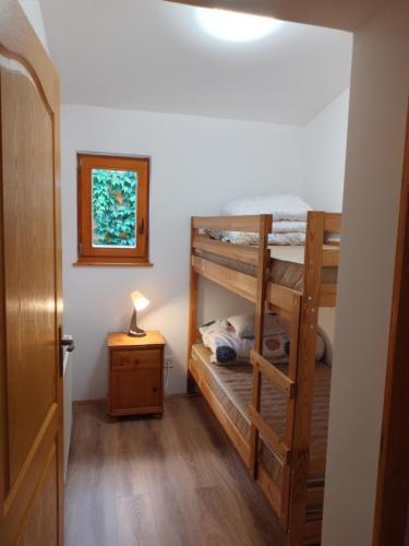 a room with two bunk beds and a lamp on a table at Halász Vendégház Tiszakécske in Tiszakécske