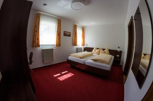 a bedroom with two beds and a red carpet at Ratskeller Niederurff - Hotel & Restaurant in Bad Zwesten