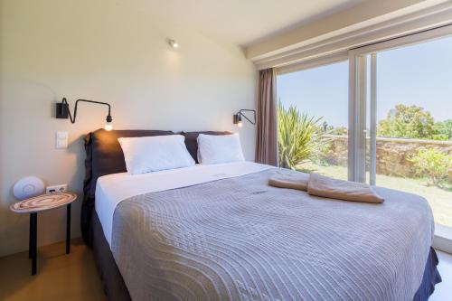 a bedroom with a large bed with a large window at Luxury Villa Gialova Neokastro with Private Pool in Gialova