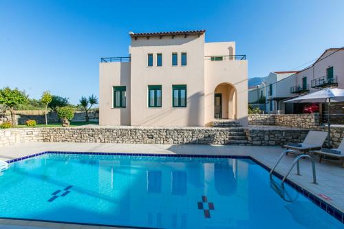 eine Villa mit einem Pool und einem Haus in der Unterkunft Villa Eleni in Asprouliánoi