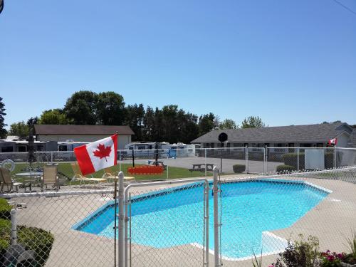 a swimming pool with a blue and white boat in front of it at Fox Motor Inn in Napanee