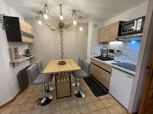 a small kitchen with a wooden table and chairs at Haut Doubs Belvédère in Les Hôpitaux-Neufs