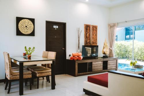a dining room with a table and chairs and a window at Layantara Villas in Layan Beach
