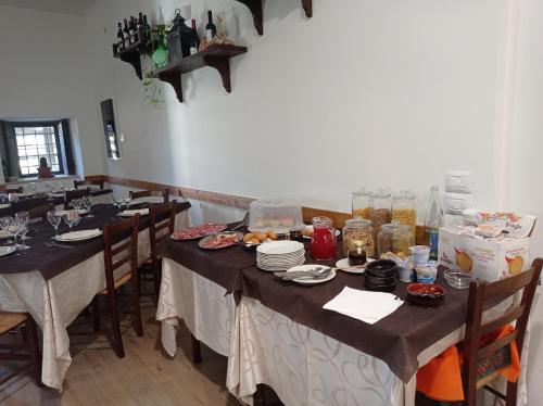 une salle à manger avec des tables et des chaises avec de la nourriture dans l'établissement AFFITTACAMERE RISTORANTE GUAITA SANT'EUTIZIO, à Preci