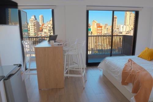 a bedroom with a bed and a desk with a laptop at Studio con amenities en Palermo - Recoleta in Buenos Aires