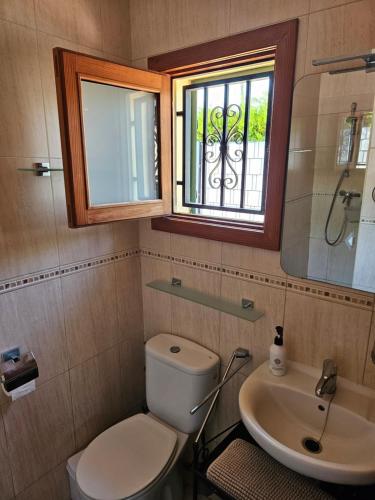 uma casa de banho com um WC, um lavatório e uma janela em Casa Heli 2 em Port d'Alcudia