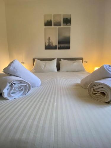 a bedroom with two beds with white sheets and pillows at Dimora Sofia in Rovetta
