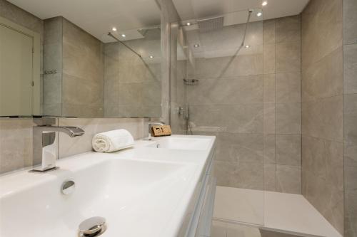 ein Badezimmer mit einem weißen Waschbecken und einer Dusche in der Unterkunft Modern holiday apartment with incredible sea views in La Cala de Mijas in Málaga