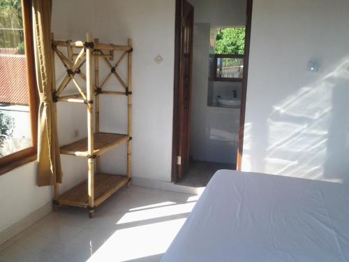 a room with a bed and a wooden book shelf at Sony Home Stay in Amed