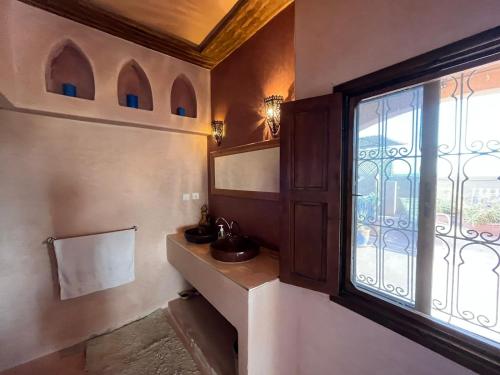 una camera con finestra con lavandino e specchio di Dar Jamila Agafay - Ait Imour a Marrakech