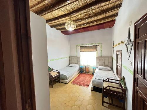 Habitación con 2 camas y ventana en Dar Jamila Agafay - Ait Imour, en Marrakech