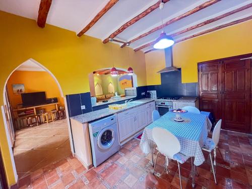 a kitchen with a table and a washing machine at Dar Jamila Agafay - Ait Imour in Marrakech