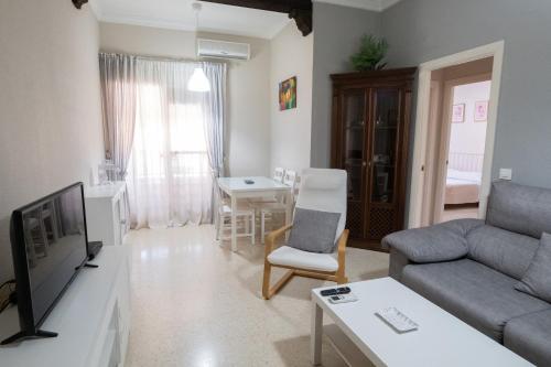 sala de estar con sofá y TV en Apartamento America, en Sanlúcar de Barrameda