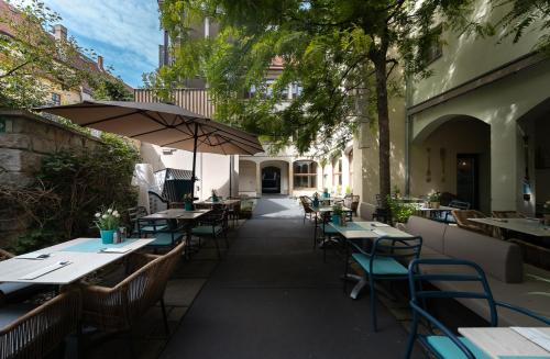 an outdoor restaurant with tables and chairs and an umbrella at Pension Donatus in Pirna