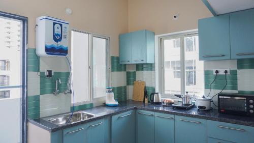 a kitchen with blue cabinets and a sink at Ashray - Vintage Homes in Hyderabad