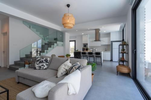 a living room with a couch and a kitchen at Villa Flora's 3-BR Retreat & Private Pool in Protaras in Paralimni