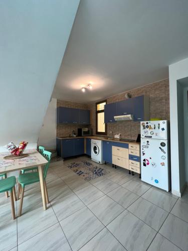 a kitchen with blue cabinets and a table and refrigerator at Casa Gino in Cotillo