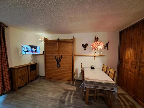 une salle à manger avec une table et une télévision dans l'établissement Appartement Montagnard Serre-Chevalier., à Saint-Chaffrey