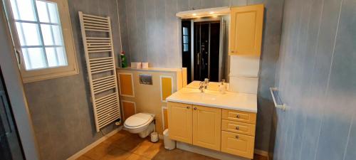 a bathroom with a sink and a toilet and a window at Villa with covered and heated swimming pool in Thiberville