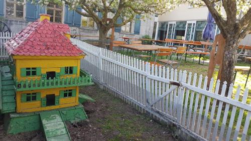 a toy house with a red roof next to a white fence at Hotel und Gasthof Ritter St. Georg in Erlangen