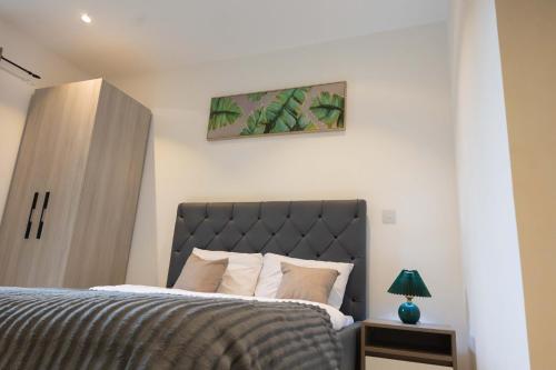 a bedroom with a bed and a picture on the wall at The Eden Suite in Accra