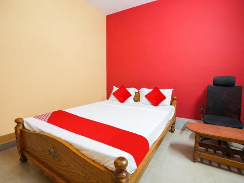 a bedroom with a bed and a desk and a chair at Hotel O Lakshmi Sri Boarding & Lodging in Bengaluru