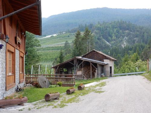 a dirt road next to a building with a mountain at Agritur Maso Forcola in Brez