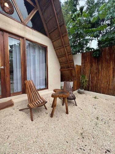 a patio with two chairs and a stool at Lodge Tzunum Jade in Tulum