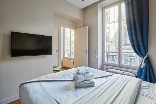 une chambre avec un lit avec des serviettes dessus dans l'établissement Apartement Champs Elysée by Studio prestige, à Paris