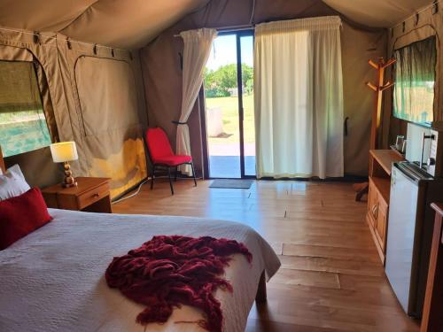 a bedroom with a bed with a red blanket on it at Eagle Ranch Lodge in Mahikeng