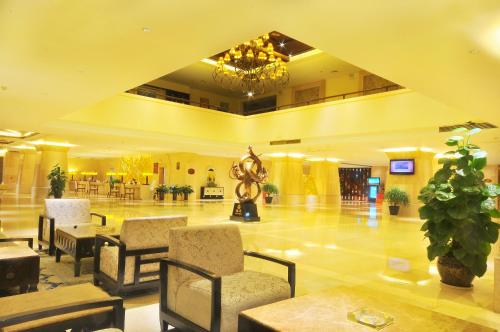 a lobby with chairs and a statue in the middle at Wenchang Waika Hotel in Wenchang