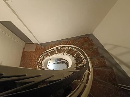 a spiral staircase in a building with wooden railings at emplacement idéal, vue mer, parking offert in Sanary-sur-Mer