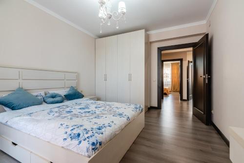 1 dormitorio con 1 cama grande con almohadas azules en ЖК Теремки en Almaty