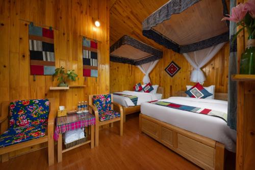 a bedroom with two beds and a table and chairs at SaPa Farmer House in Sa Pa