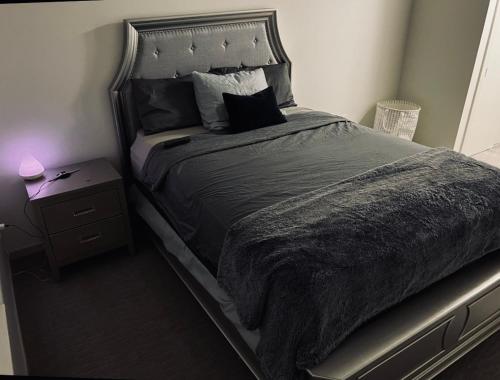 een slaapkamer met een groot bed en een nachtkastje bij Downtown Detroit Rental in Detroit