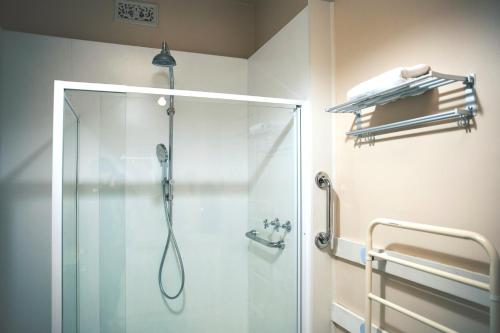 a shower with a glass door in a bathroom at Incredible Waterview - 4 Bedroom Hobart Waterside Cottage in Sandy Bay