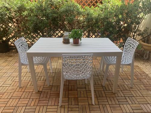 uma mesa branca e cadeiras com um vaso de plantas sobre ela em Kite Village Solaris em Birgi Vecchi
