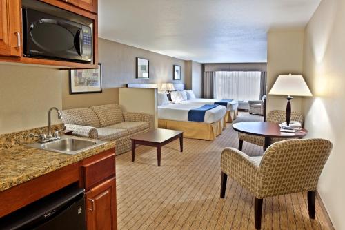 ein Hotelzimmer mit einem Bett und einem Wohnzimmer in der Unterkunft Holiday Inn Express Hotel & Suites Vancouver Mall-Portland Area, an IHG Hotel in Vancouver