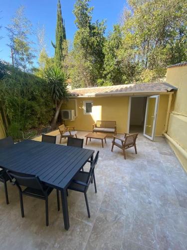 - une table de pique-nique et des chaises sur la terrasse dans l'établissement Superbe appartement à 5 minutes à pied de la mer, à Toulon