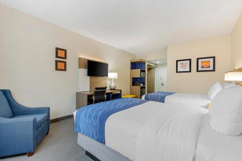a hotel room with two beds and a chair at Comfort Inn Herndon-Reston in Herndon