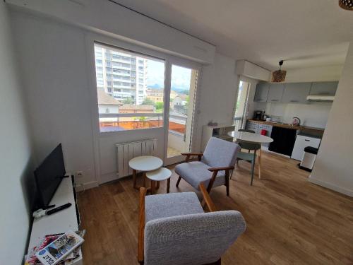 un salon avec une table et des chaises et une cuisine dans l'établissement Studio Central, à Thonon-les-Bains