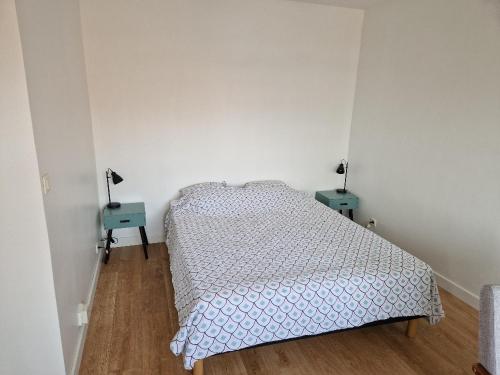 - une chambre avec un lit et deux tables bleues dans l'établissement Studio Central, à Thonon-les-Bains
