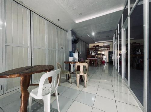 a hallway with a table and chairs in a building at A and A Bed and Breakfast Inn powered by Cocotel in Legazpi