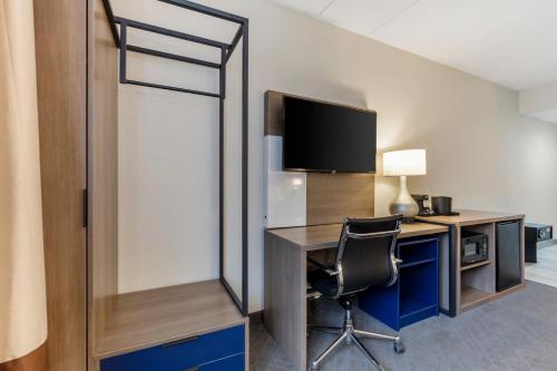 a room with a desk with a television and a chair at Comfort Inn Herndon-Reston in Herndon