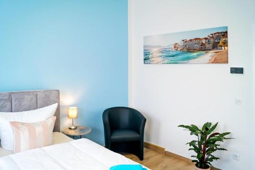 een slaapkamer met een bed en een zwarte stoel bij Die ideale Wohnung in Solingen