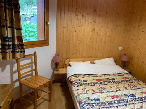 a bedroom with a bed and a chair and a window at Paradiski proche des pistes plan peisey in Peisey-Nancroix