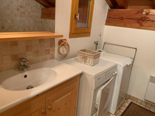 a bathroom with a sink and a counter with a mirror at Paradiski proche des pistes plan peisey in Peisey-Nancroix