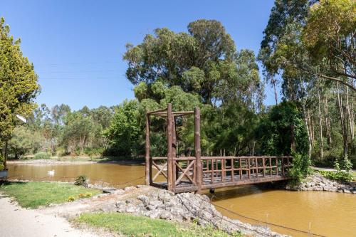a wooden bridge over a river in a park at Quinta das Murgas in Bucelas
