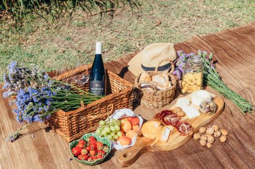 a picnic with a basket of food and a bottle of wine at Quinta das Murgas in Bucelas