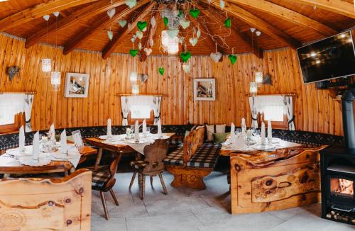 ein Esszimmer mit Holzwänden, Tischen und Stühlen in der Unterkunft Gasthof Pension Perauer in Lieserhofen